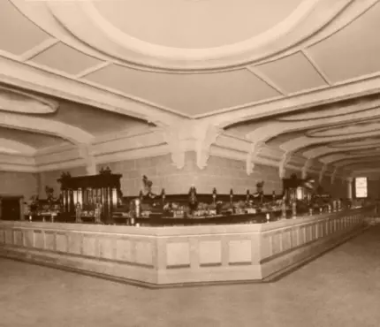 Sepia-toned image of an ornate, empty bar with a long counter and decorative ceiling.